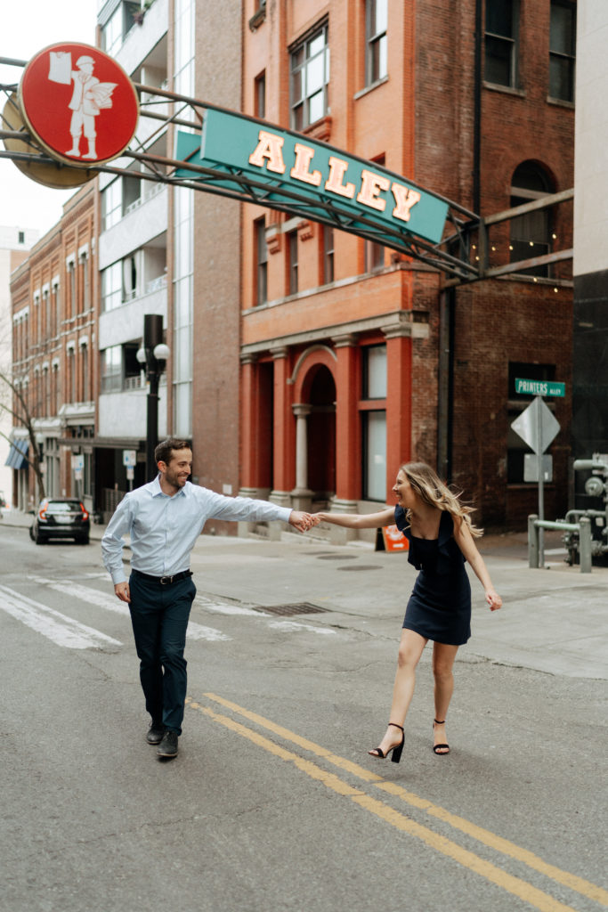 A couple posing for an engagement session in downtown Nashville