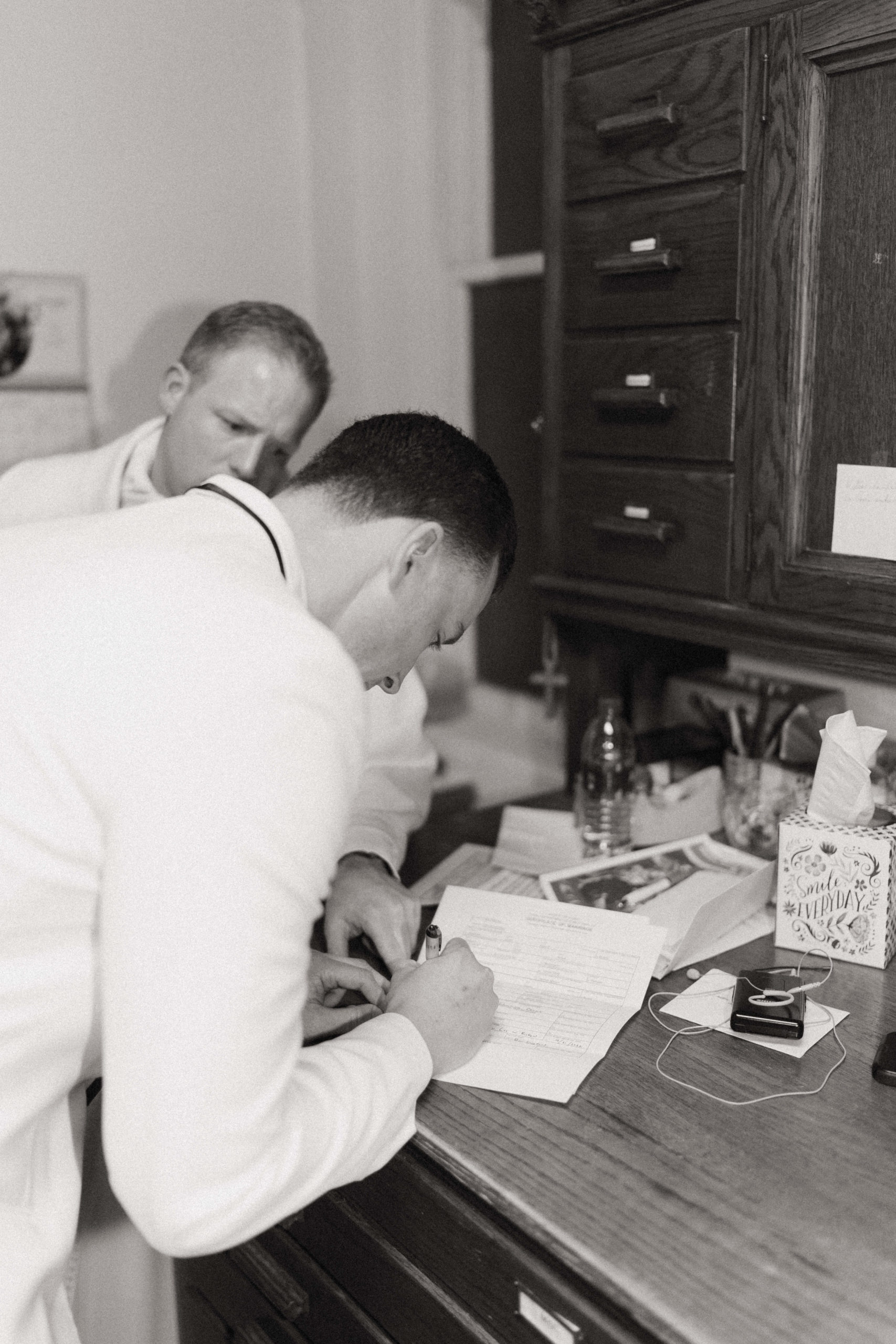 This is a picture of a groom signing the wedding papers