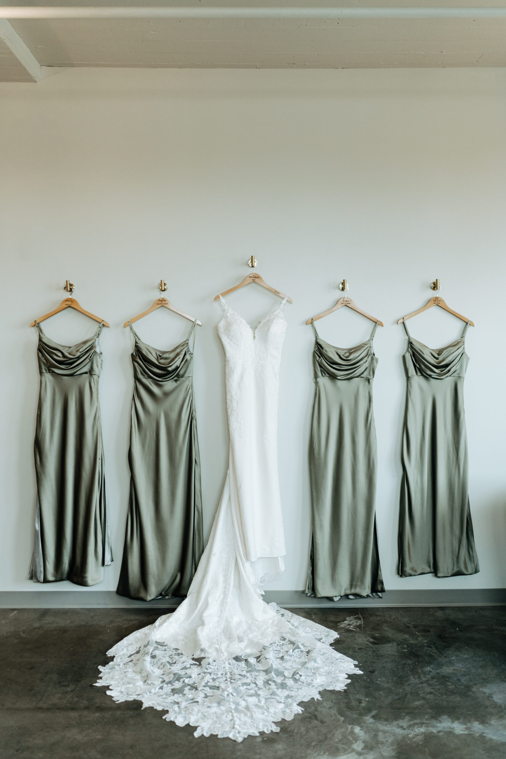 This is a picture of a wedding dress with bridesmaid dresses next to it