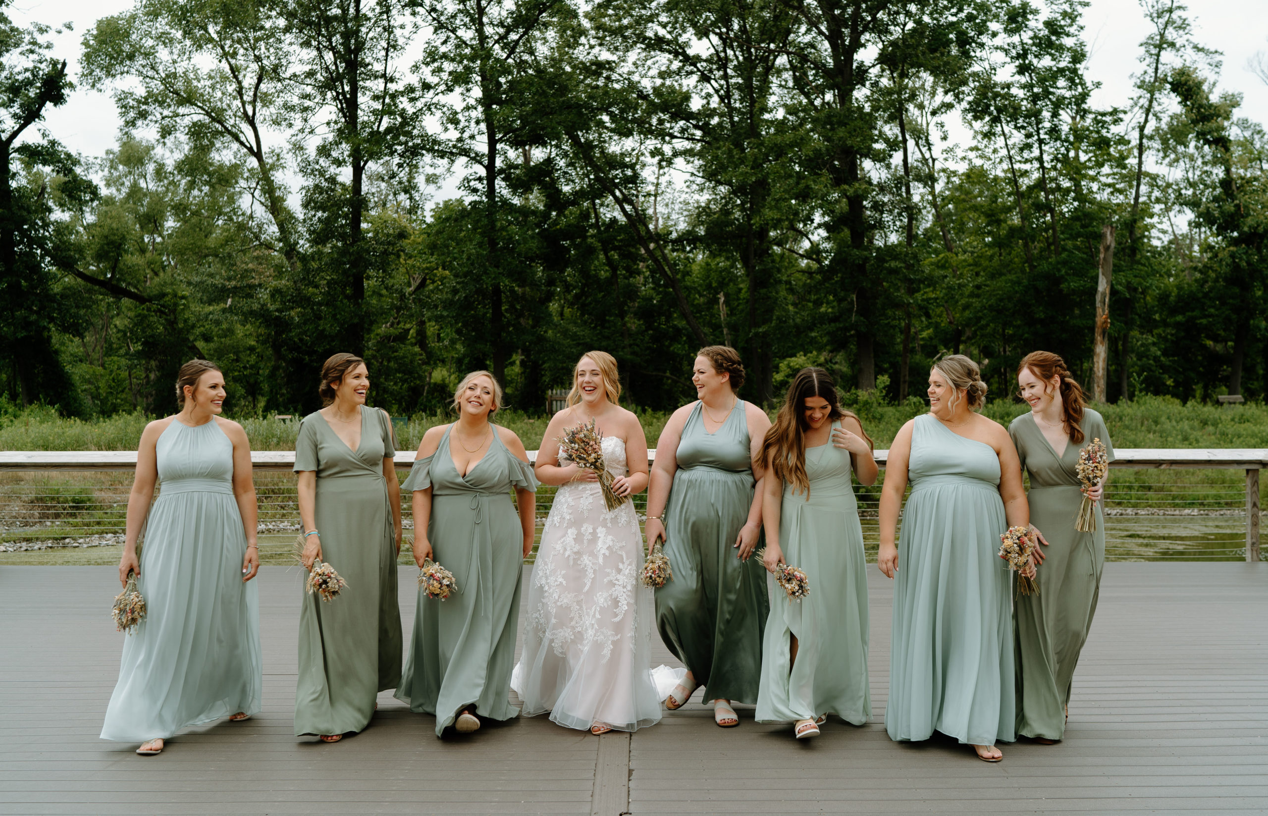 This is a group of bridesmaids taking a picture with the bride on her wedding day