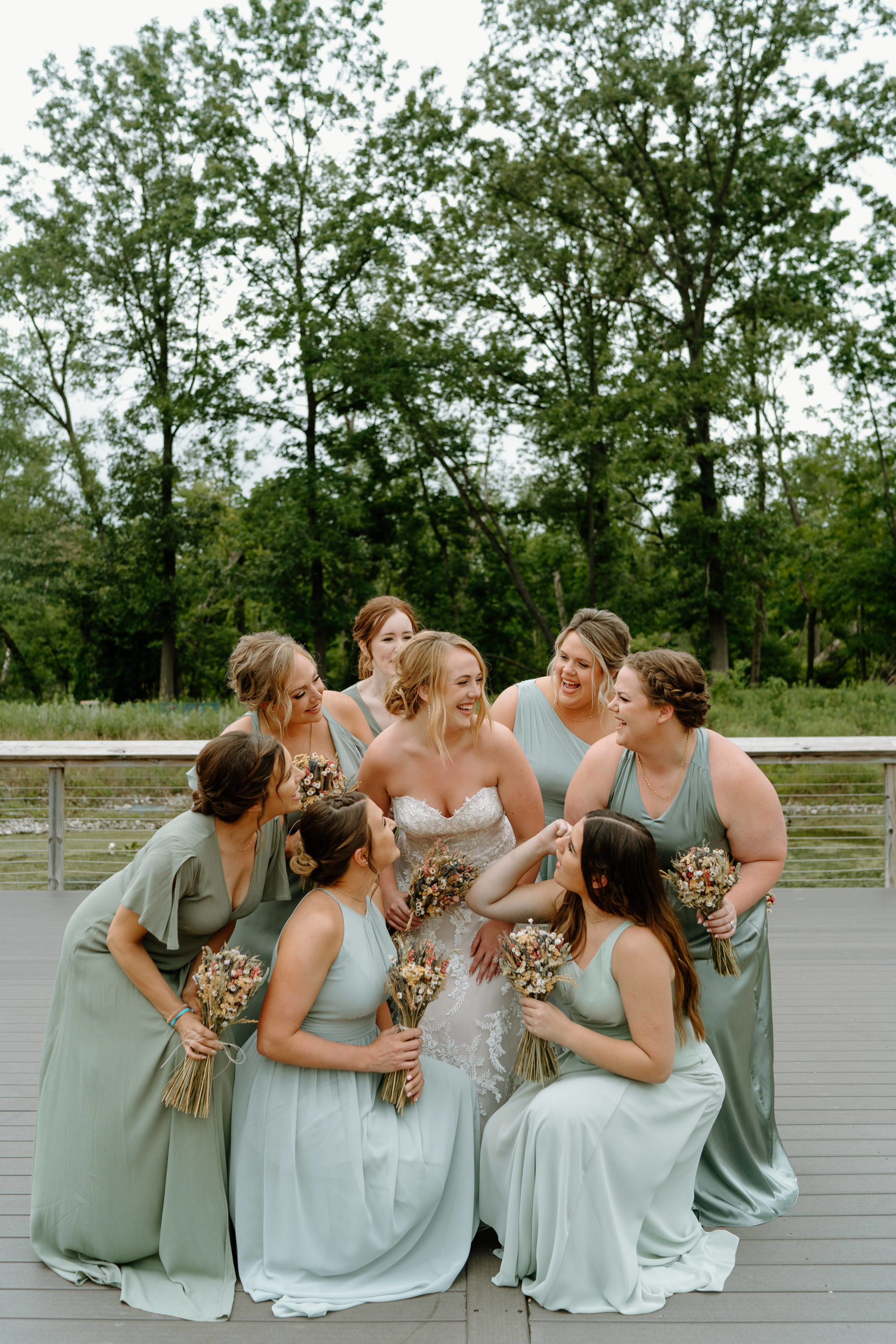 This is a group of bridesmaids taking a picture with the bride on her wedding day