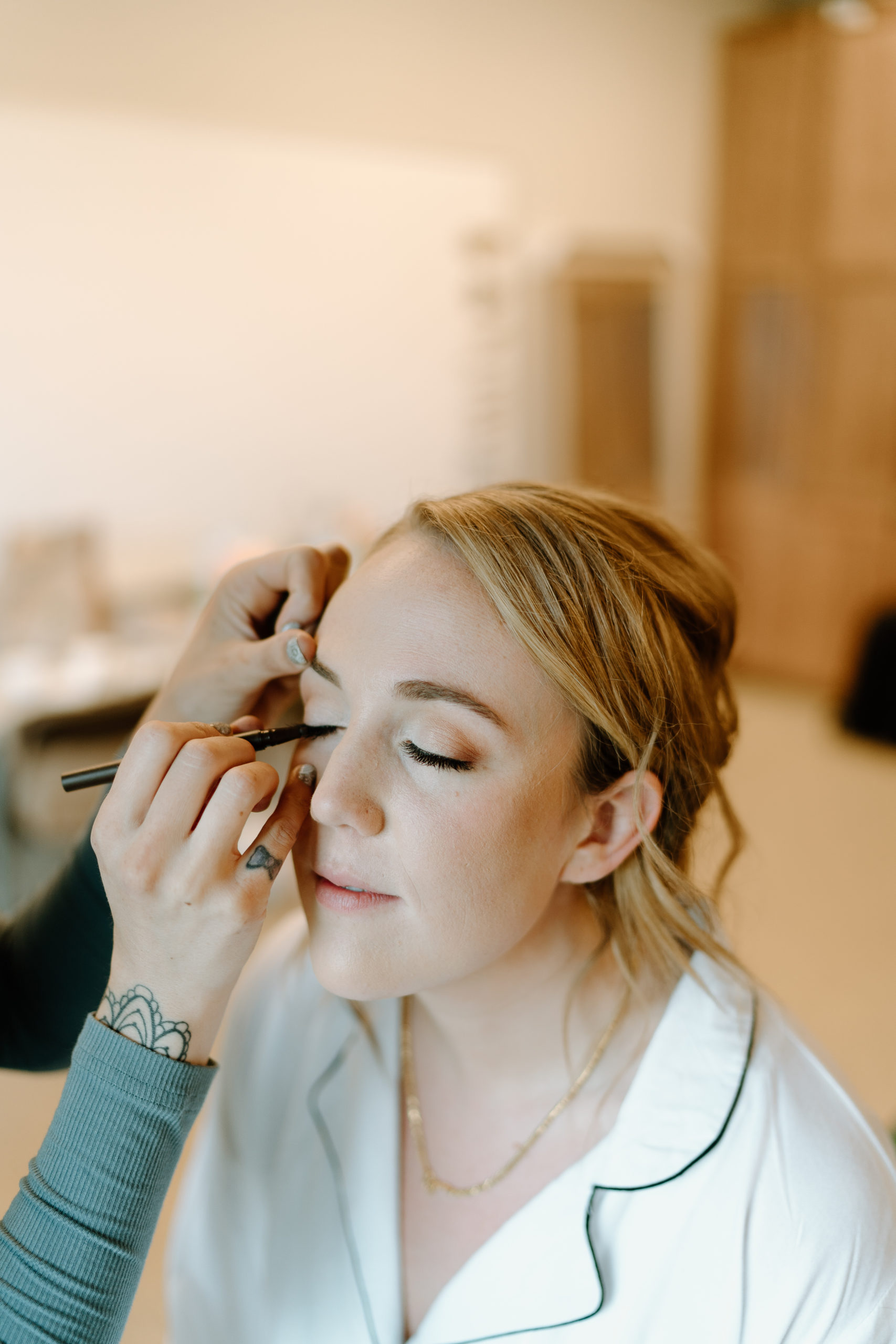 This is a picture of a bride getting her makeup done on her wedding day