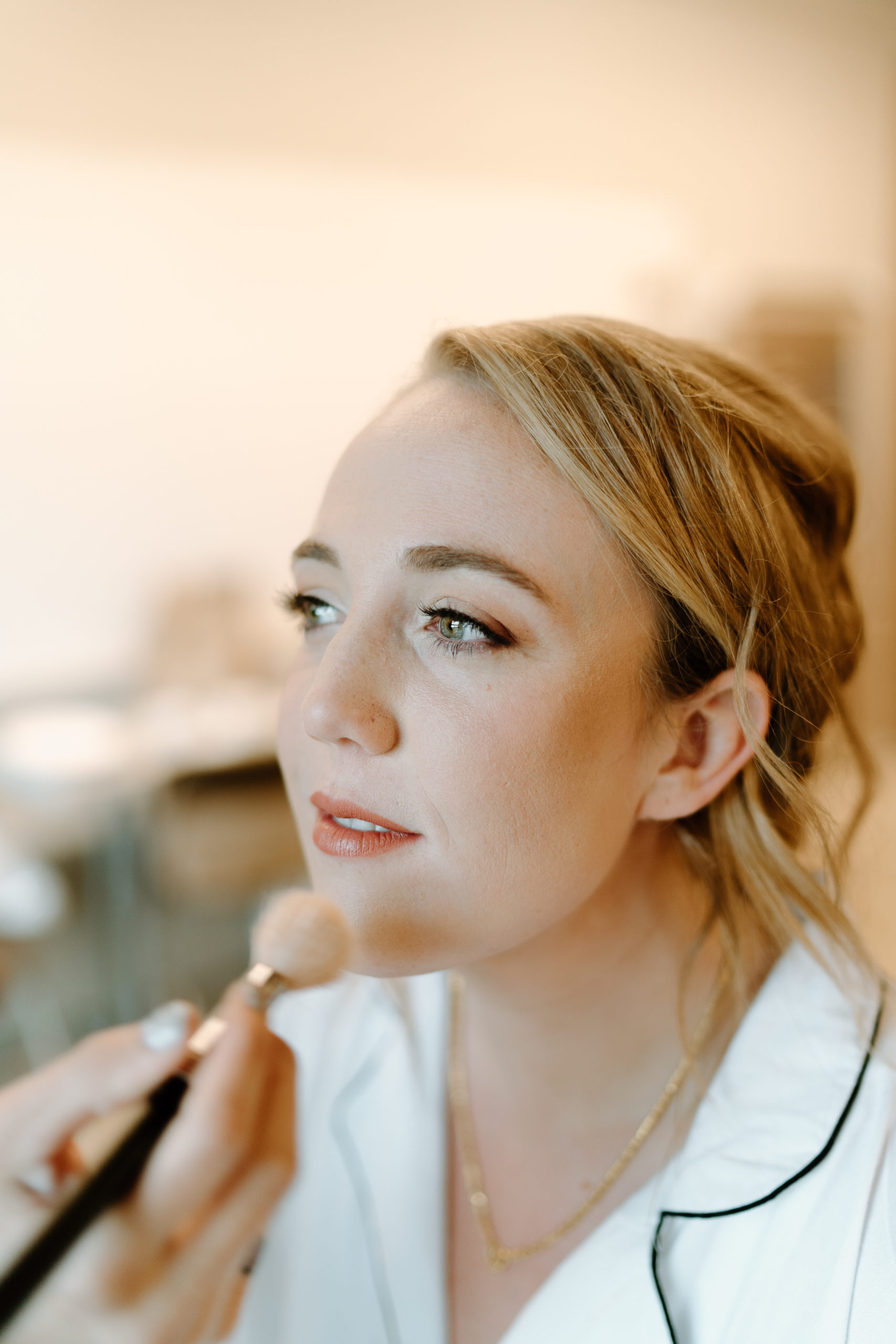 This is a picture of a bride getting her makeup done on her wedding day