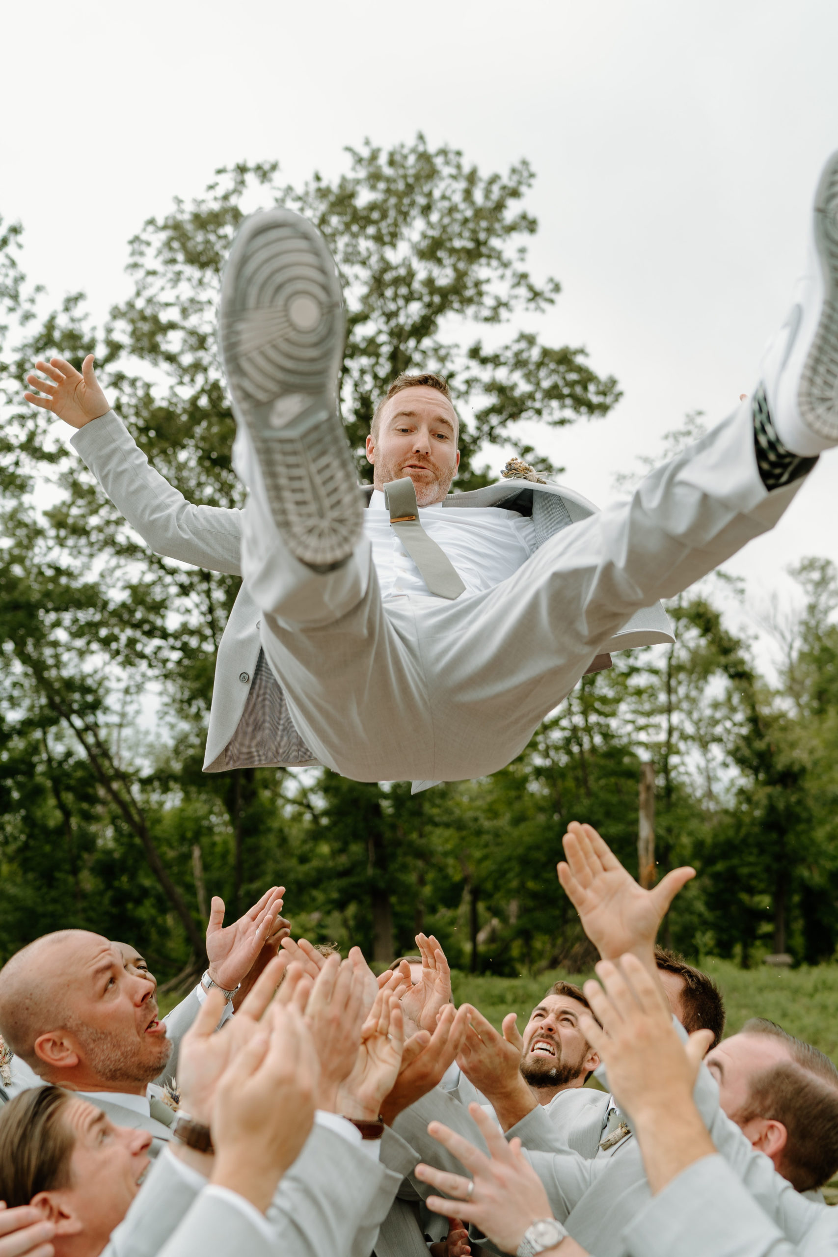 This is a groom being thrown in the air on his wedding day