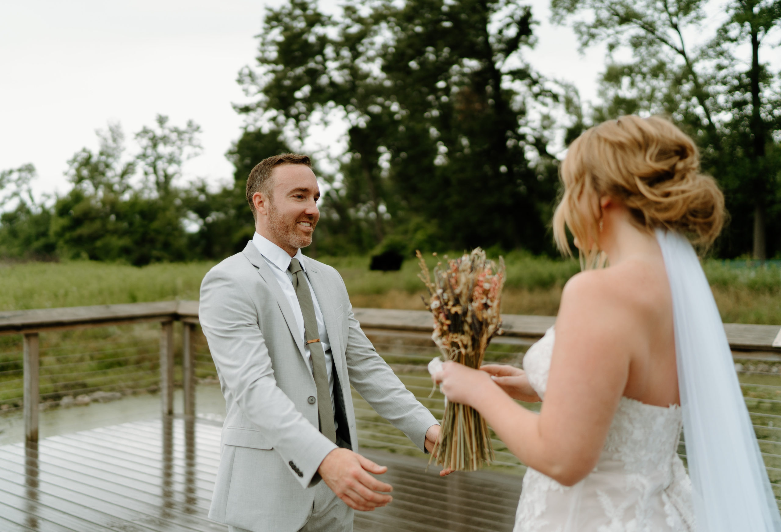 This is a bride and groom doing their first look on their wedding day at Indian Creek Nature Center in Cedar Rapids, IA