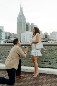 man proposing with the nashville skyline behind them in nashville tn
