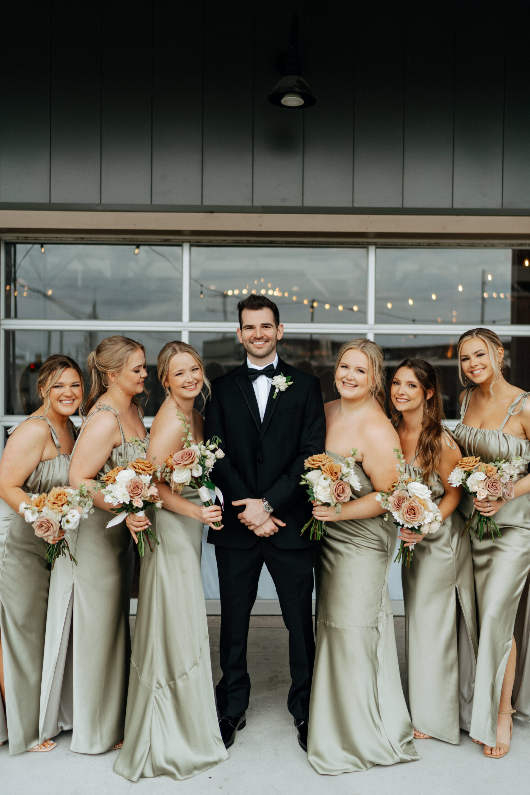 Groom with bridesmaids taking pictures on her wedding day at 14TENN in Nashville, TN