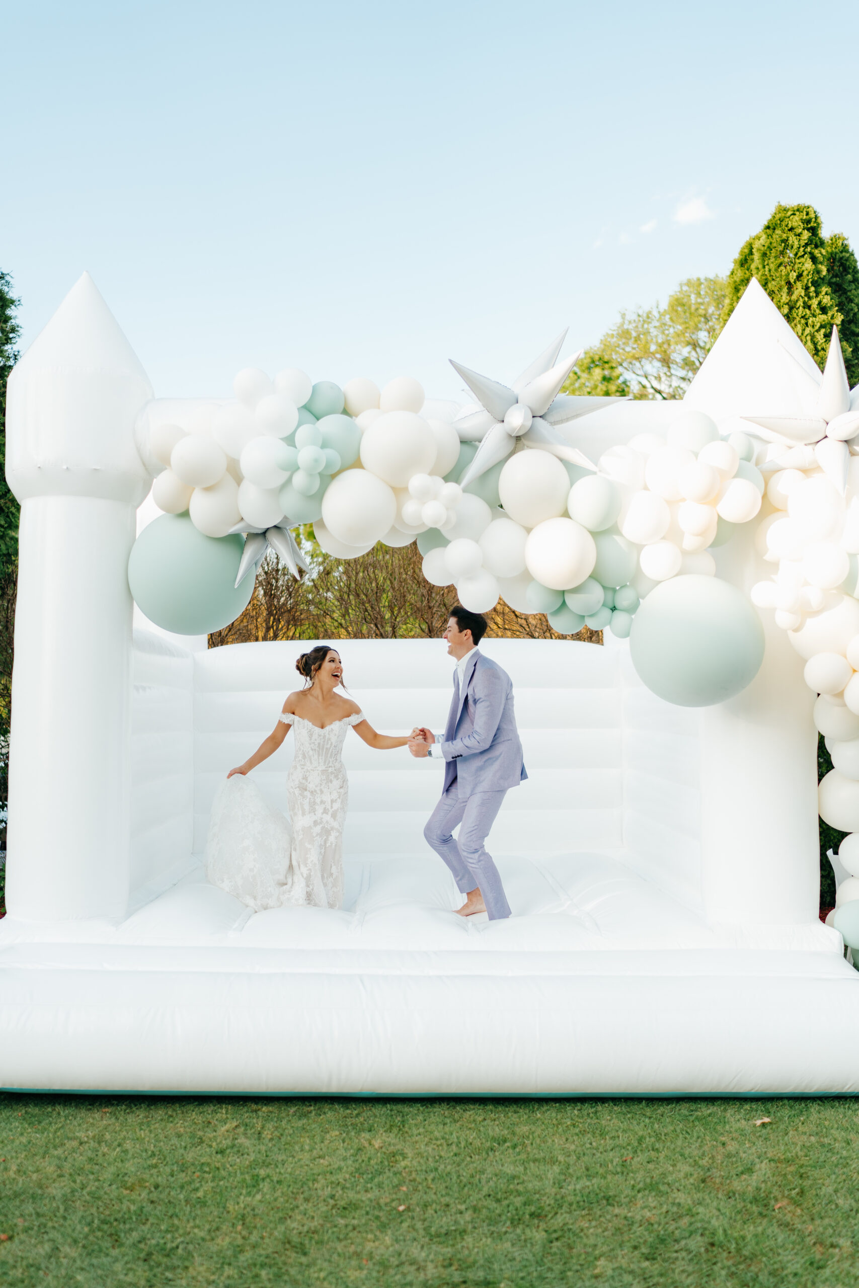couple bouncing in bounce house on their wedding day