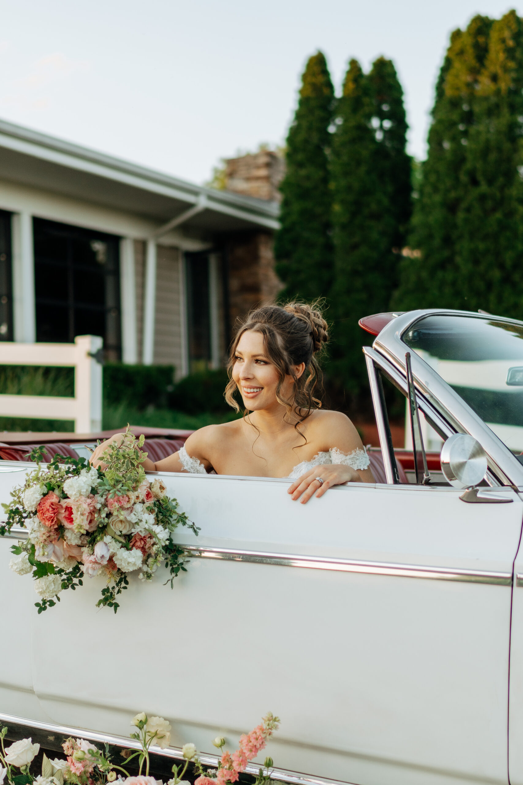 couple posing in front of vintage car on their wedding day